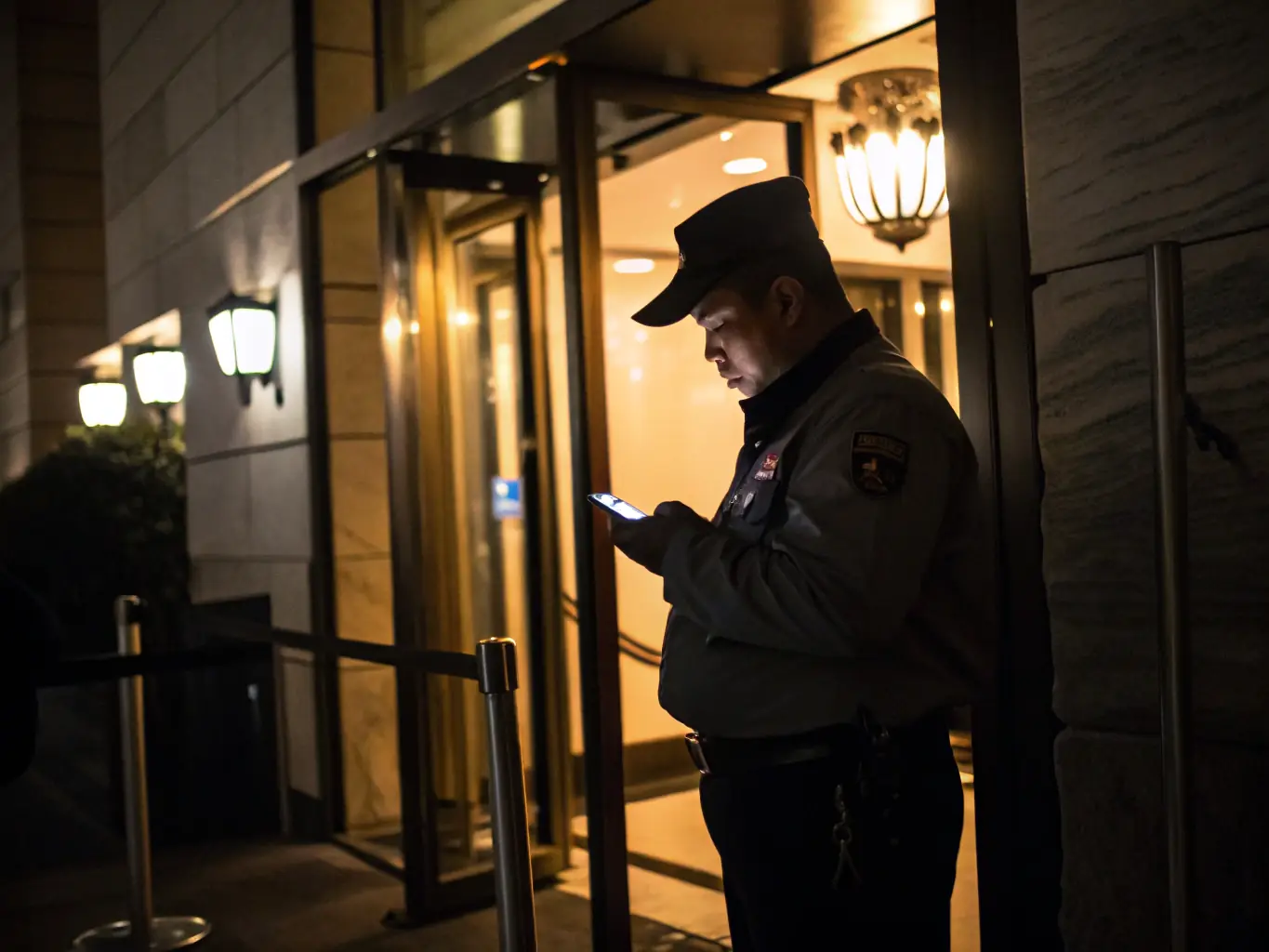 A security guard using a handheld device to scan and verify credentials at a secure access point, demonstrating the use of technology in access control.
